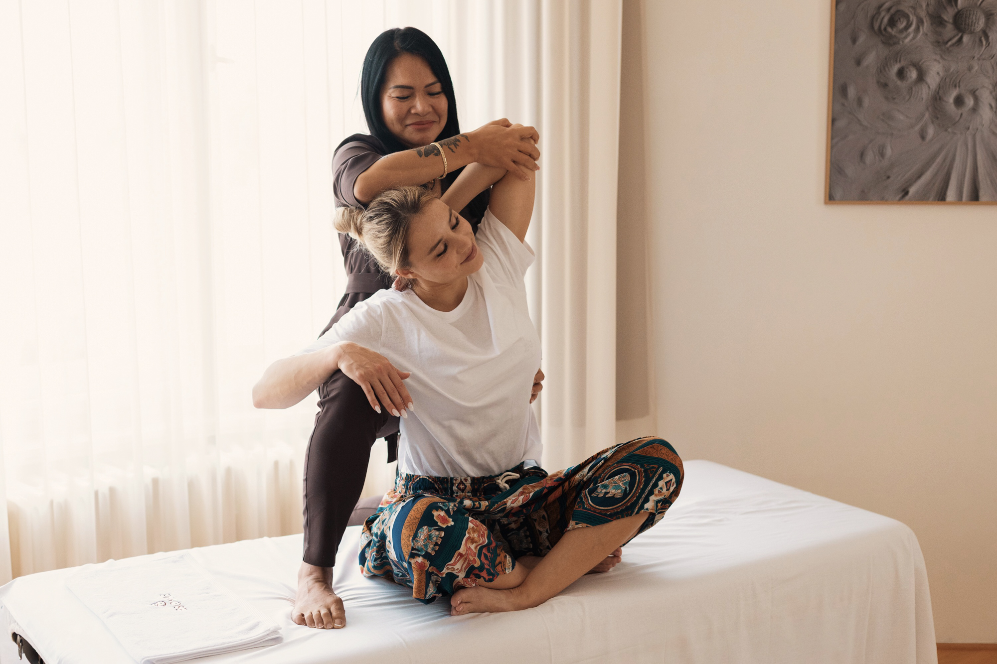 Thajská terapeutka ESCAPE provádí traditional Thai stretch u klienta doma